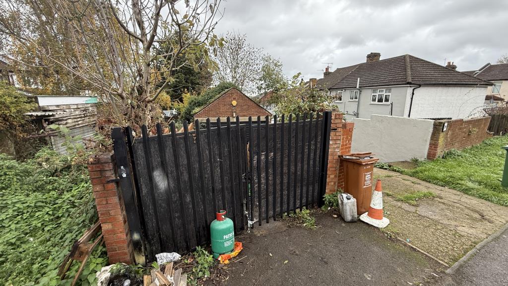 Lot: 26 - FREEHOLD GARAGE AND YARD WITH POWER LIGHTING AND GATED FRONTAGE - External image of garage and yard with gates closed